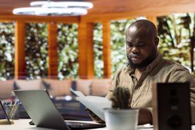 Man in his home office looking at documents.