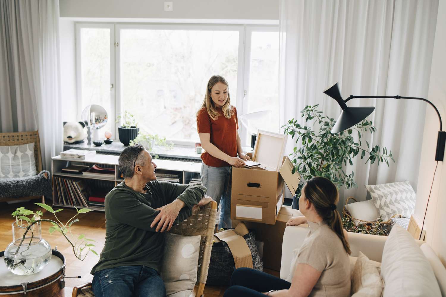 A woman talks with her parents while packing boxes