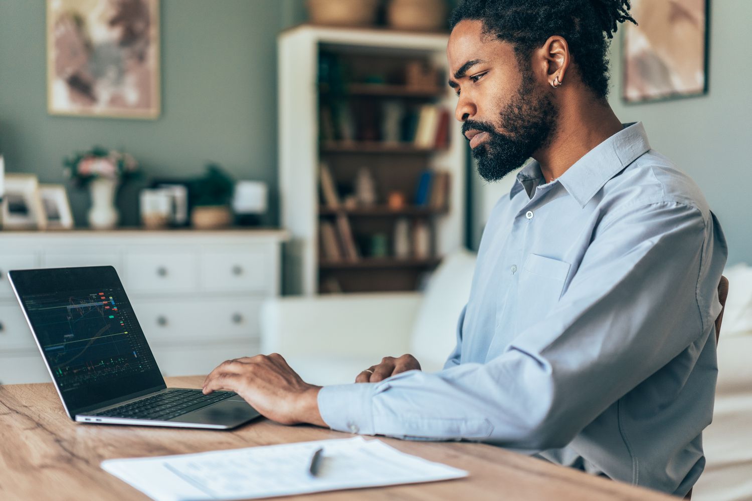 Business man trading forex on his laptop at home. 