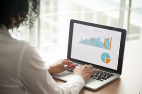 A woman examining statistics on a laptop