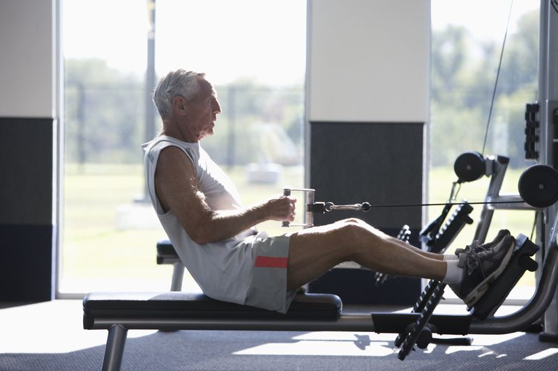 Side view of older man exercising in a gym