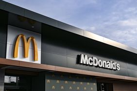 The McDonald's name and "golden arches" logo are seen on the side of a black building.