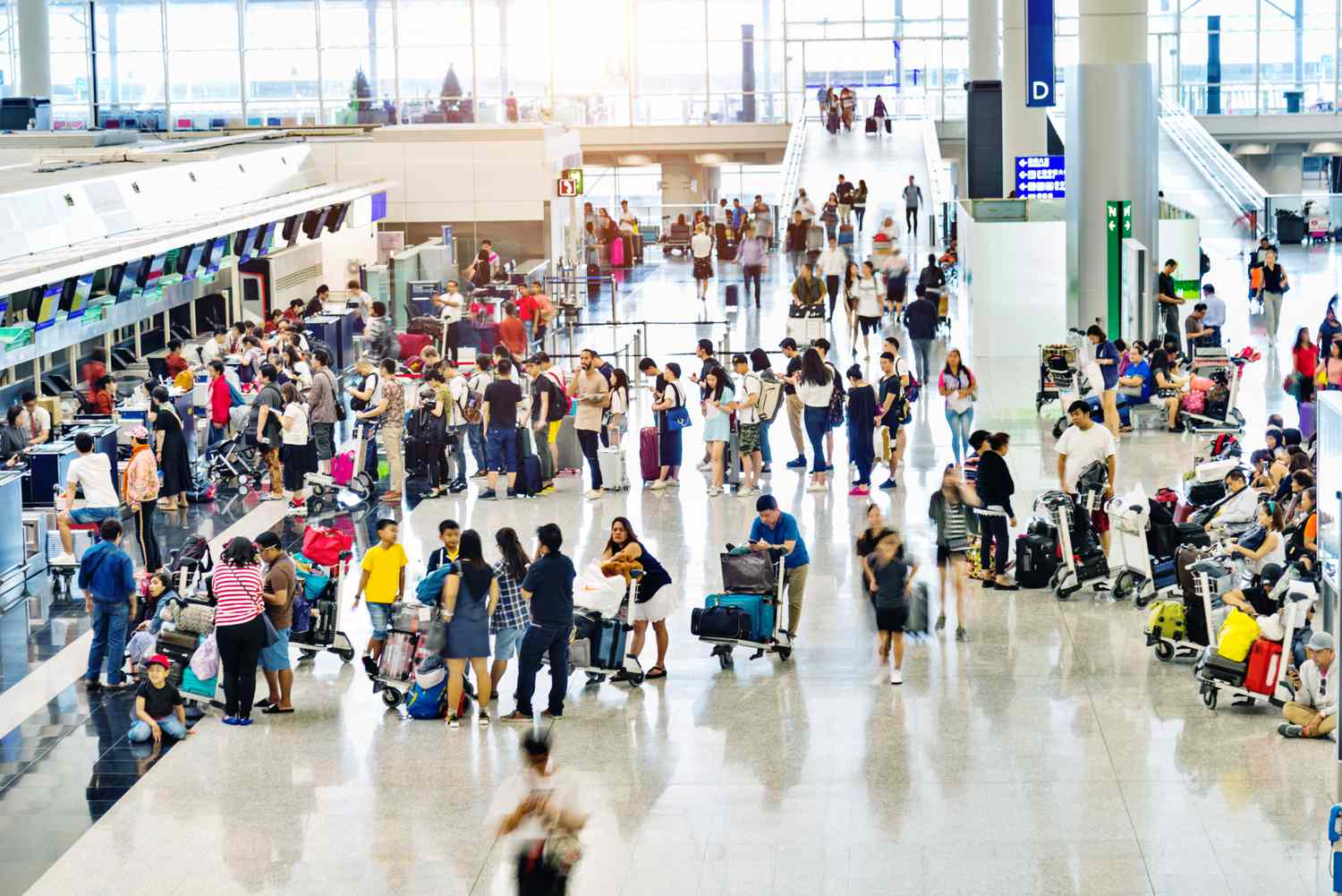 A stock image of travelers waiting in line at an airport. 