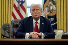 President Donald Trump sits at the Resolute Desk.