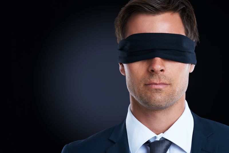 A blindfolded man in a suit