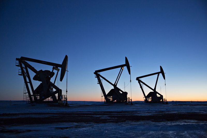 The silhouettes of pumpjacks are seen above oil wells in the Bakken Formation