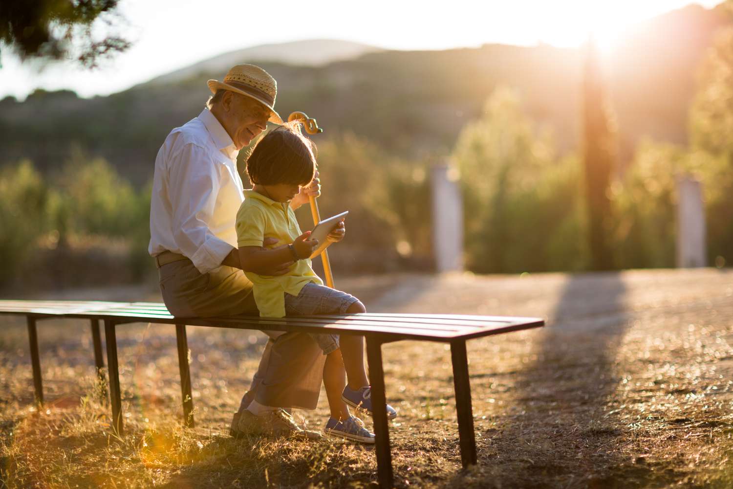 A grandfather and grandson sitting on a bench