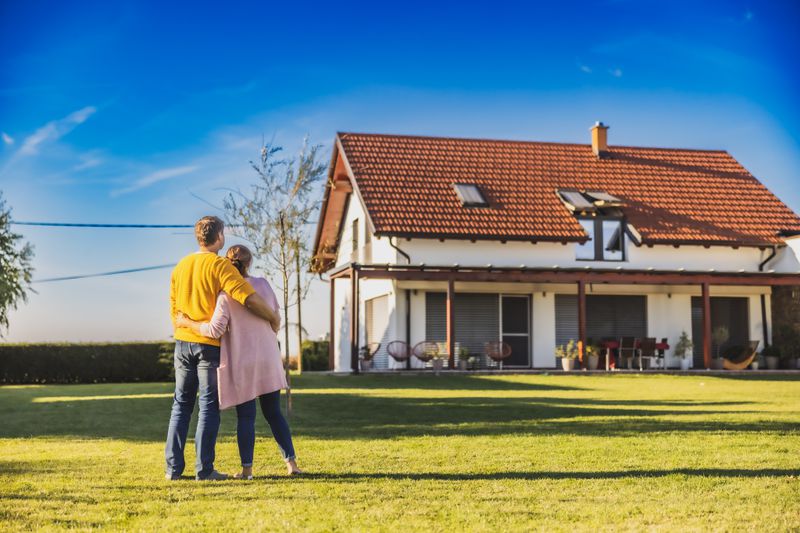 Couple standing in front of a newly purchased single family home