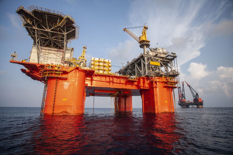 A new offshore oil platform is situated near an older platform that it will be replacing.