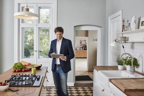 Insurance inspector walking through home with tablet doing insurance inspection