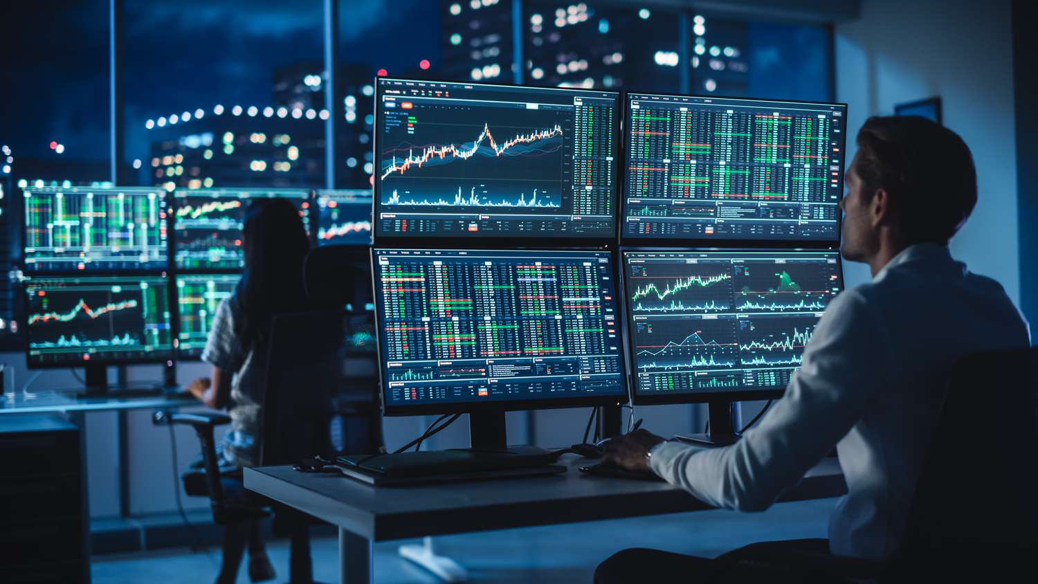 A tactical trader studying multiple charts on computer monitors.