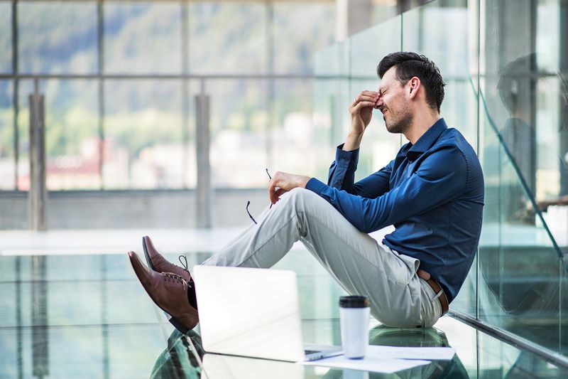 Frustrated Young Man with Laptop, Sitting on the Floor