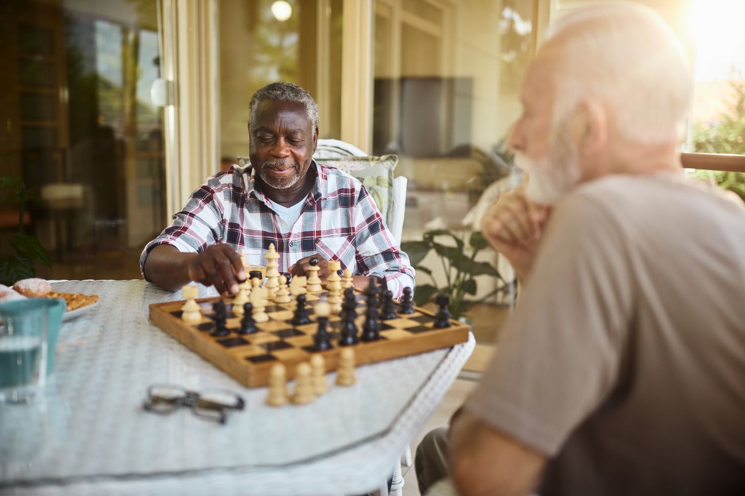 Older man playing chess with another older man