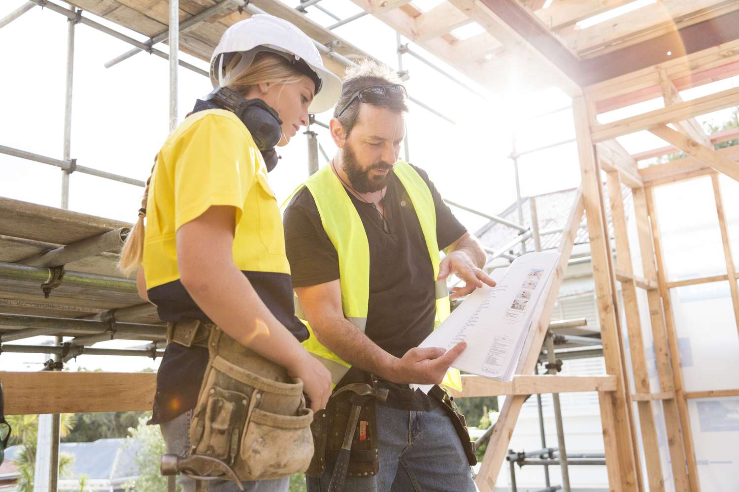 Construction workers discuss the building plans inside the building site