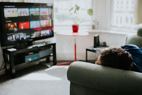 Man rests on the couch and considers what to stream.