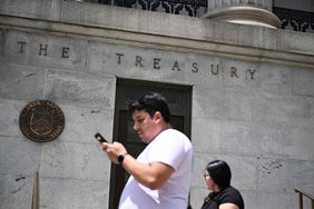 Pedestrians walk outside Treasury building