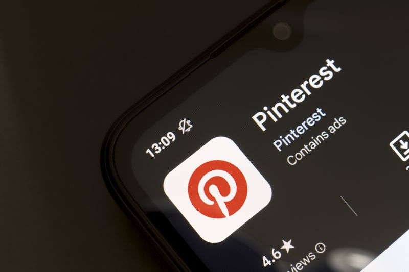 The App Store page for Pinterest is seen on a smartphone screen on a dark background.