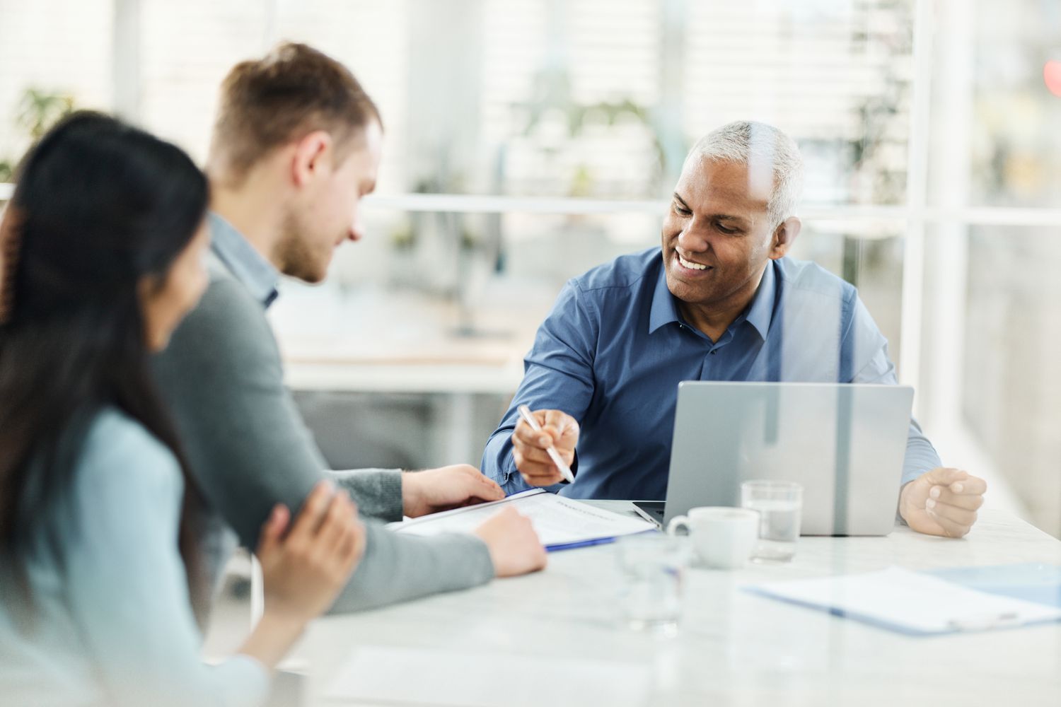 A couple reviewing mortgage documents with a banker.
