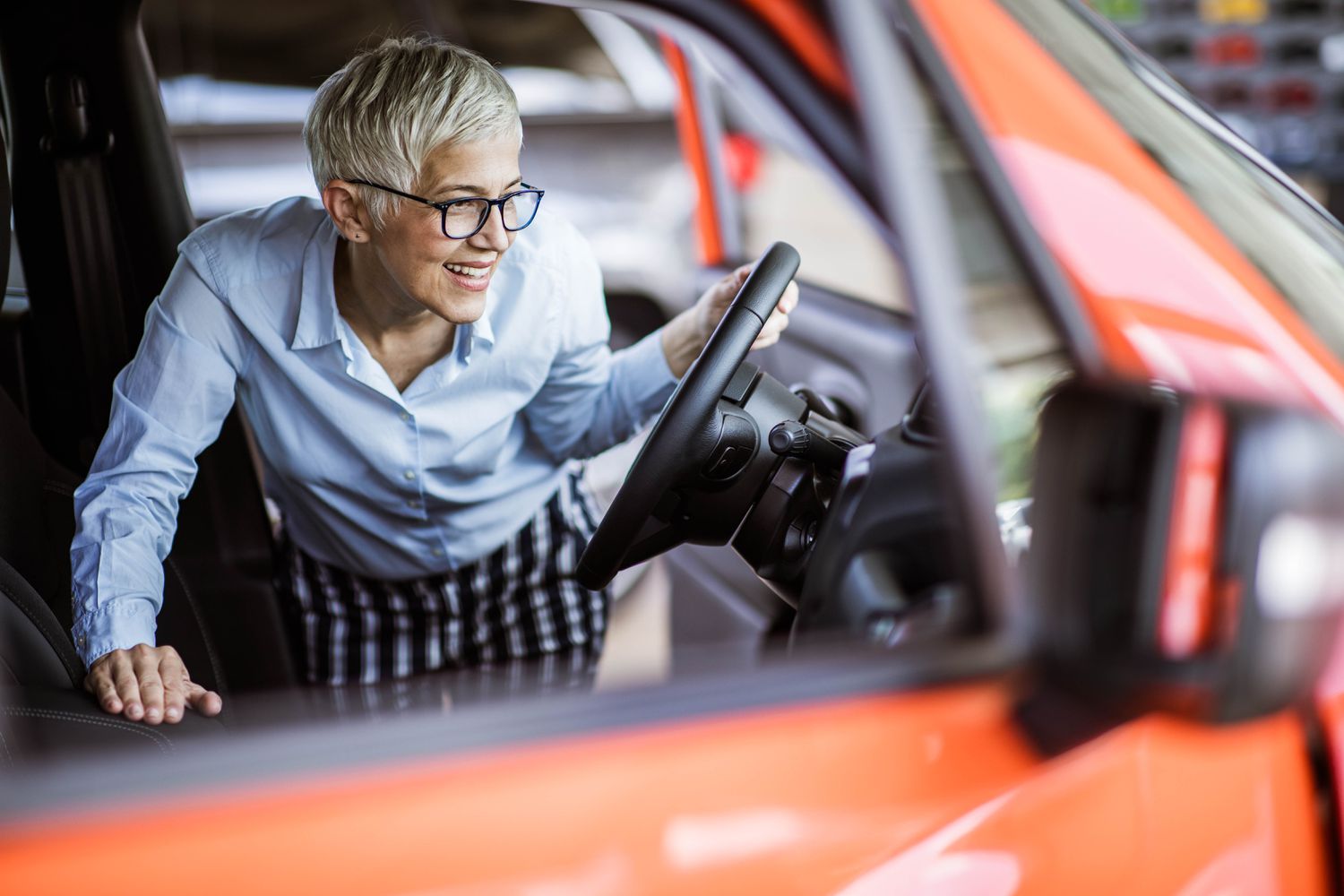 A woman inspects a car.