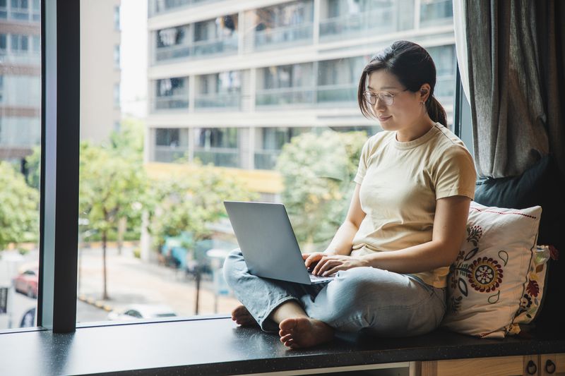 Asian Woman Sitting With Laptop Computer