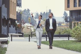 Real estate agent pointing out a building to a client