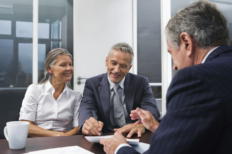 Middle aged couple talking to Financial Advisor -