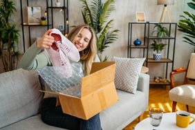 A woman taking shoes out of an online package