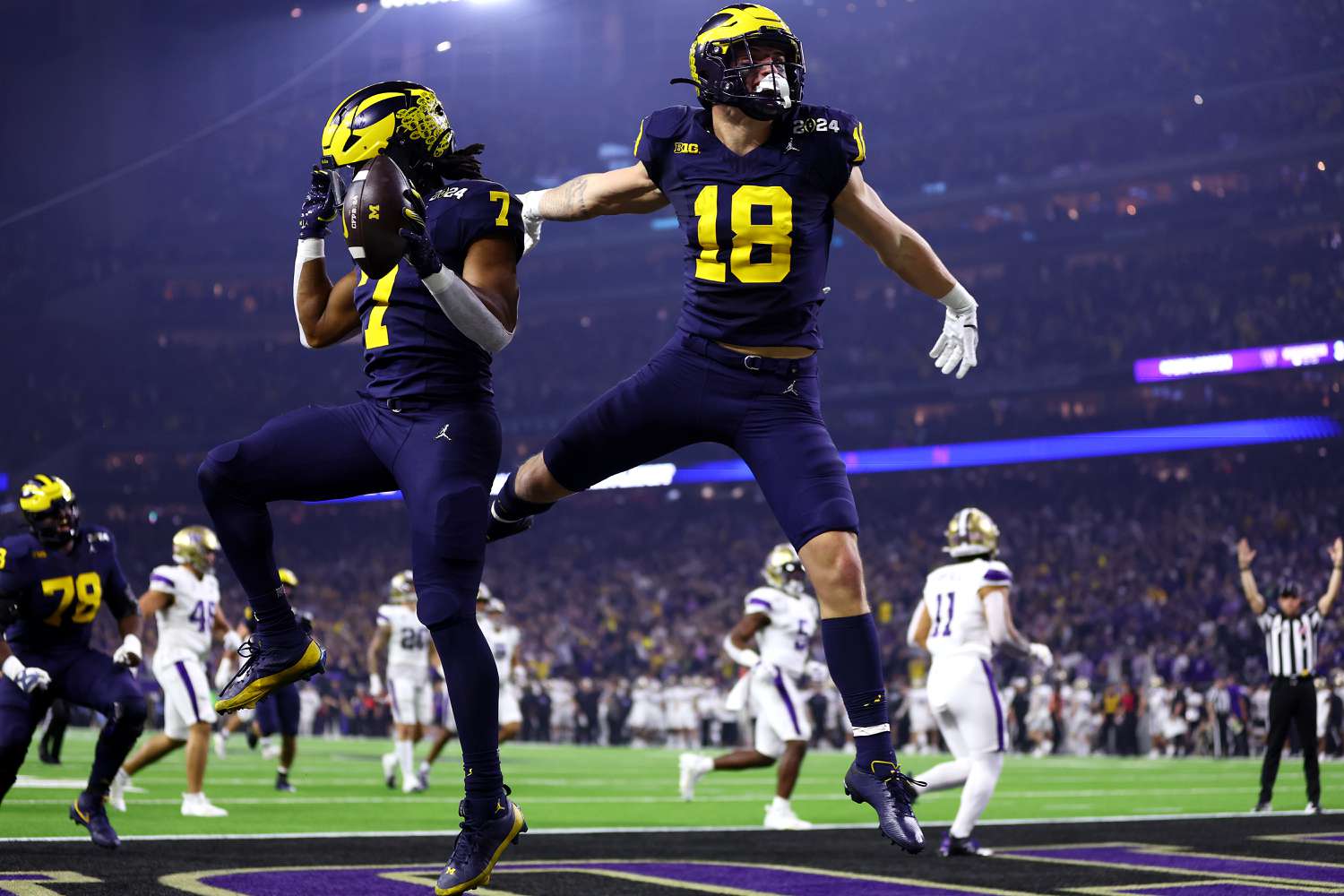 Donovan Edwards #7 of the Michigan Wolverines celebrates with Colston Loveland #18 after running the ball for a touchdown in the first quarter against the Washington Huskies during the 2024 CFP National Championship game at NRG Stadium on January 08, 2024 in Houston, Texas. 