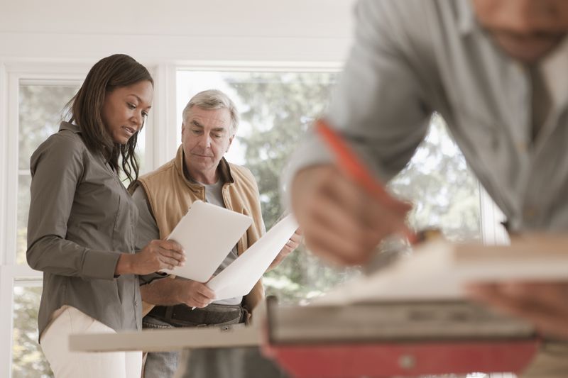 Woman and two men looking at plans