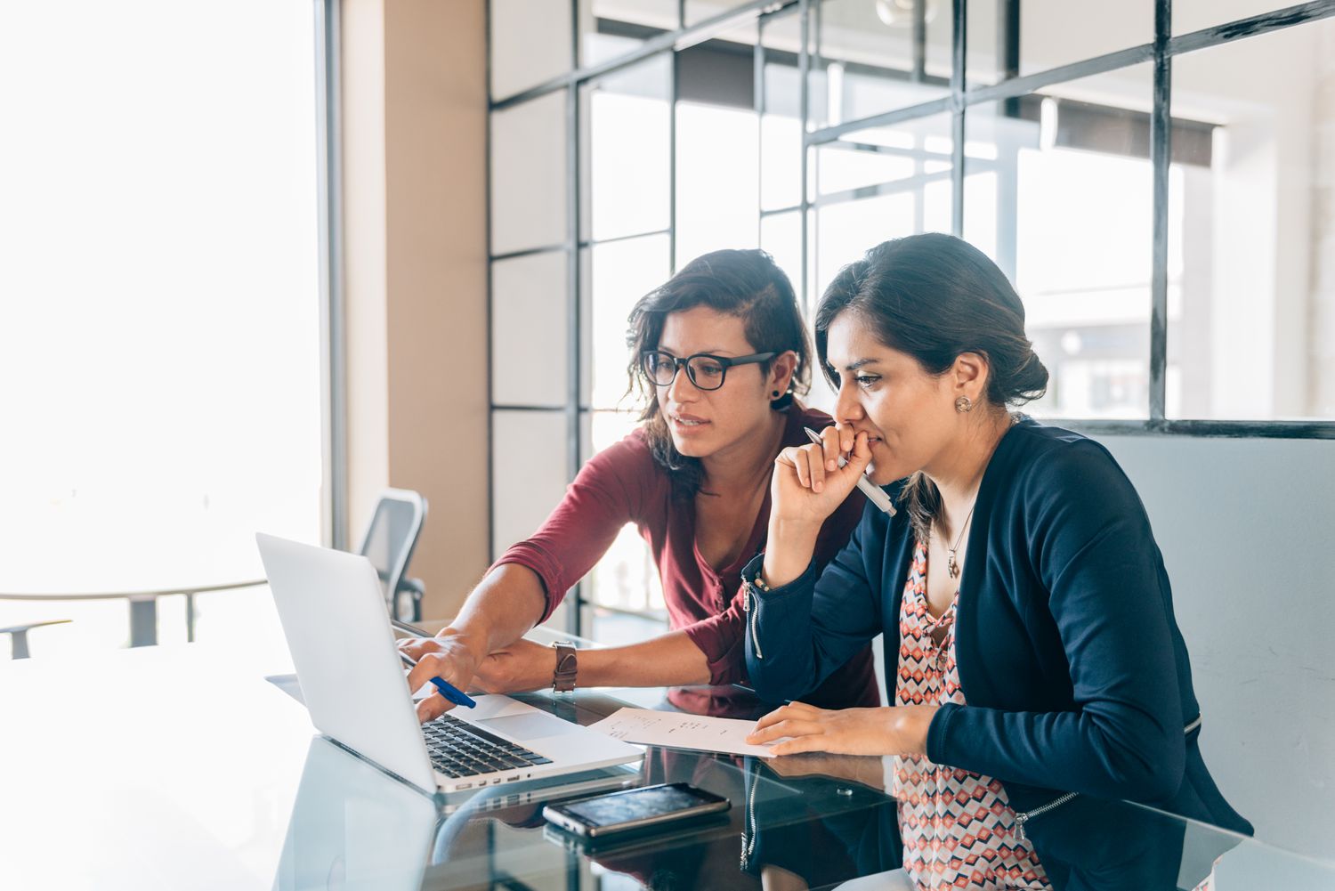 Two women discussing something on a laptop