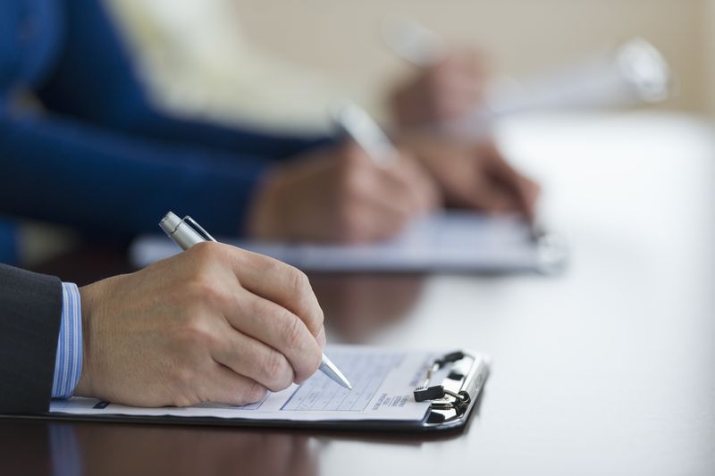 People checking documents before signing to avoid moral hazard or adverse selection.