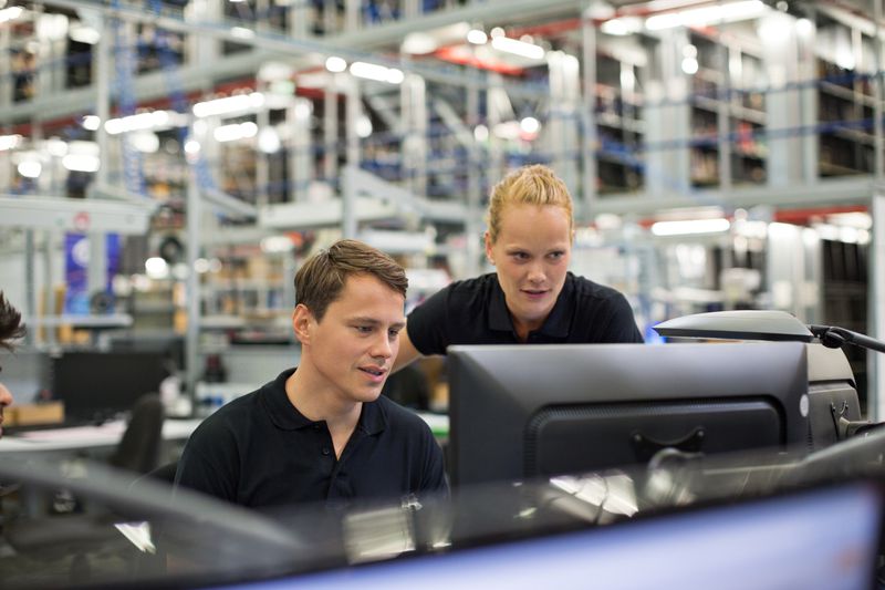 Man and woman looking at computer in logistics warehouse