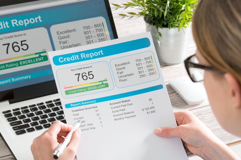 A person looking at a credit report to compare it with the national average and average credit score by state.