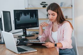 Beginner trader studying material from a day trading course while practicing on trading account.