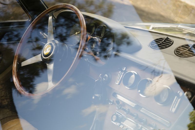A Vintage Ferrari dashboard viewed through window.