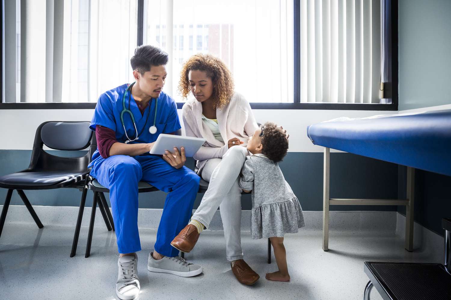 Doctor talking to a mother holding her child in a hospital