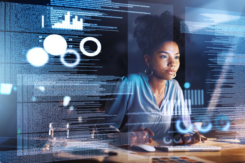 Analyst reviews a computer screen showing merger and acquisition financial data