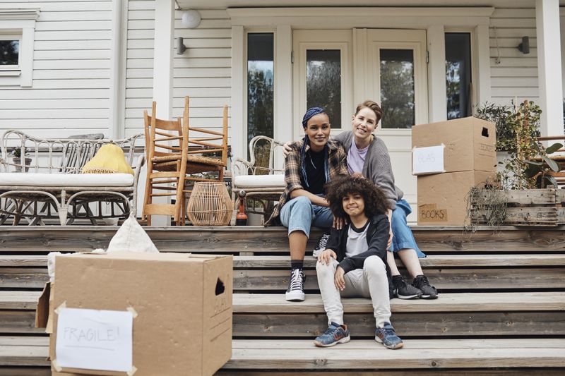 Portrait of family with son sitting on steps outside house