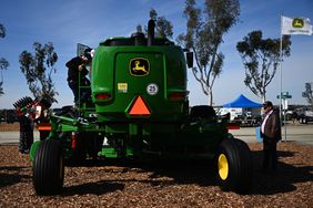The John Deere logo is displayed as attendees view farm equipment at the Deere & Co. booth during the World Ag Expo at the International Agri-Center in Tulare, California on Feb. 11, 2025