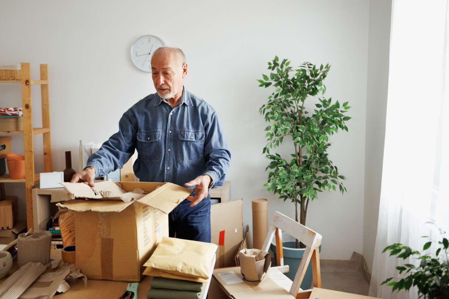 Senior man getting order ready for delivery at his home based workshop