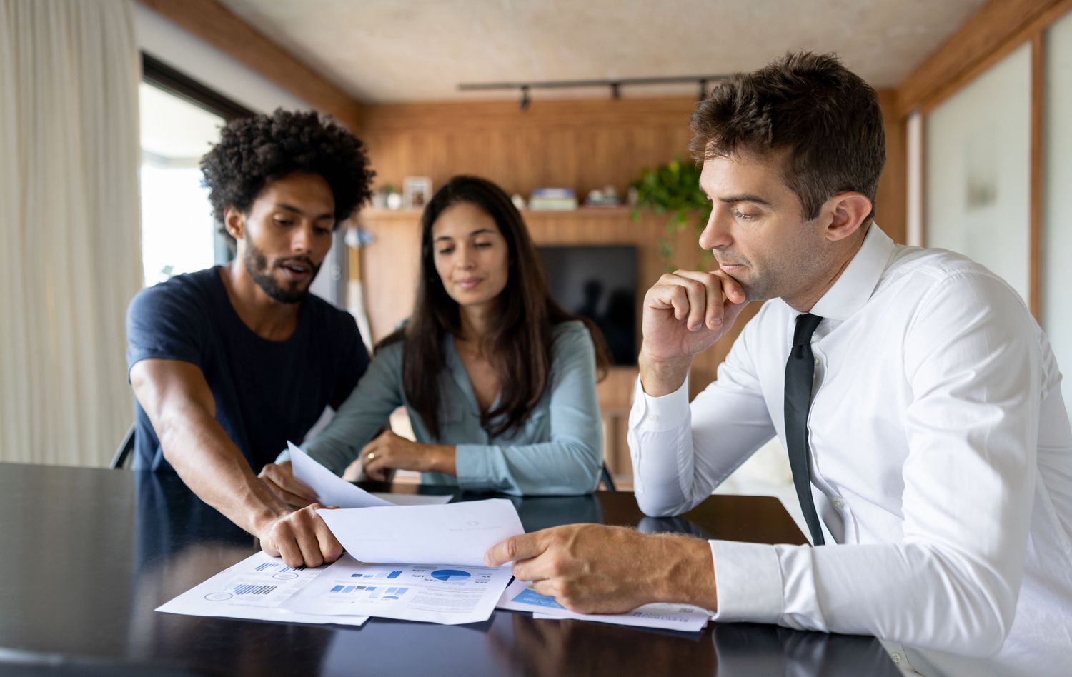 A couple talking about paperwork with an advisor at home