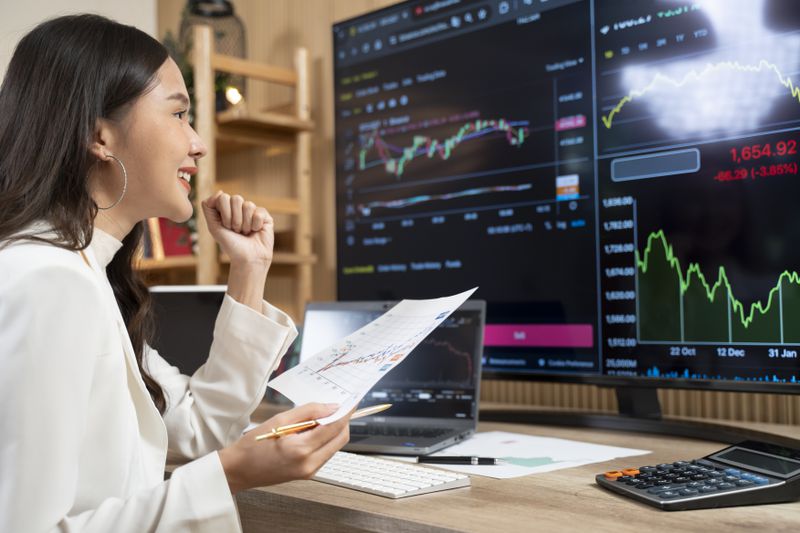 A statistical arbitrage trader raises their fist and smiles after completing a positive trade from price differences of a security.