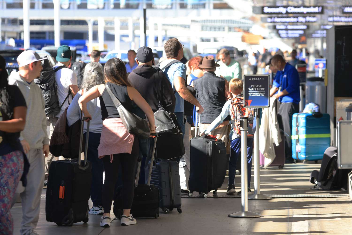 Crowds wait in check-in line at an airport terminal.