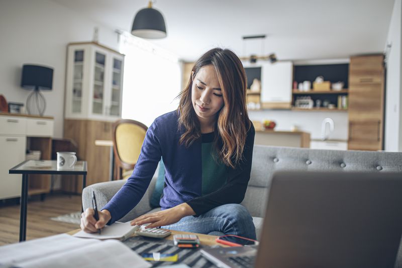 A young woman doing her finances at home.