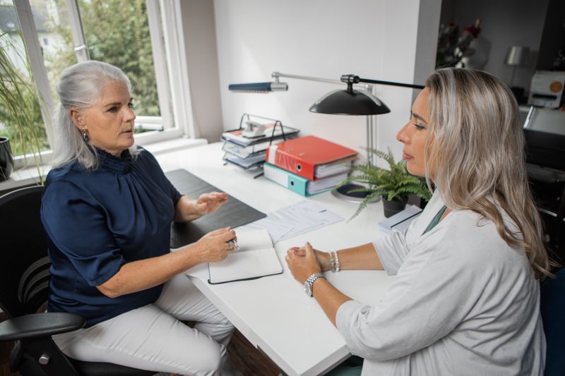 Two women sitting at a desk in an office