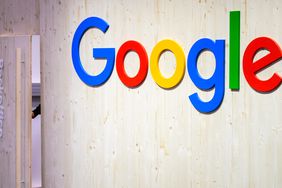 An employee closes the door of the back office next to a Google logo at the Google stand at Hannover Messe 2024