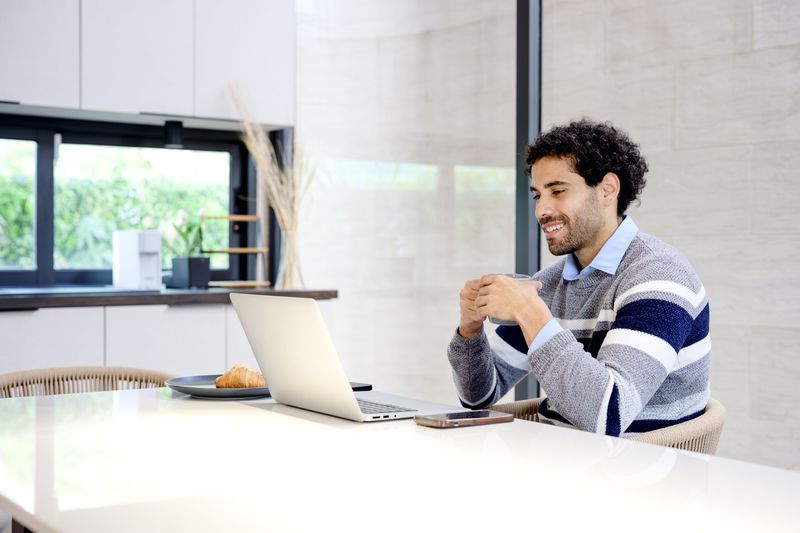An investor uses a laptop computer to review online investments using portfolio management software. 