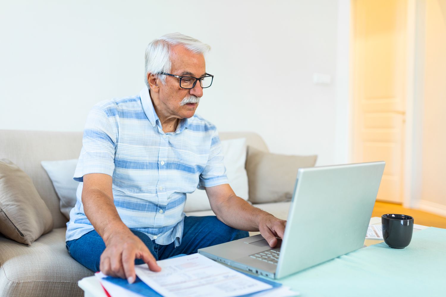 An investor uses a laptop to determine how much profit they will realize if they sell a portion of shares they hold in their retirement account.