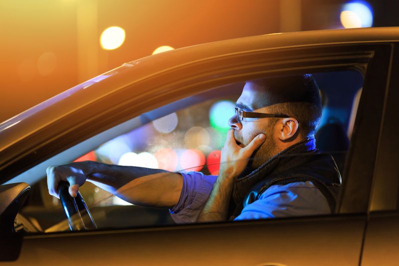 Driver in car at night with lights outside