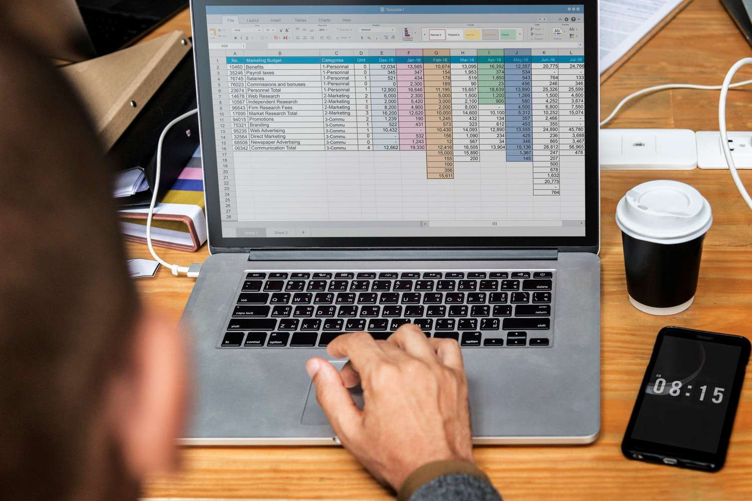 Person using excel on Mac laptop.